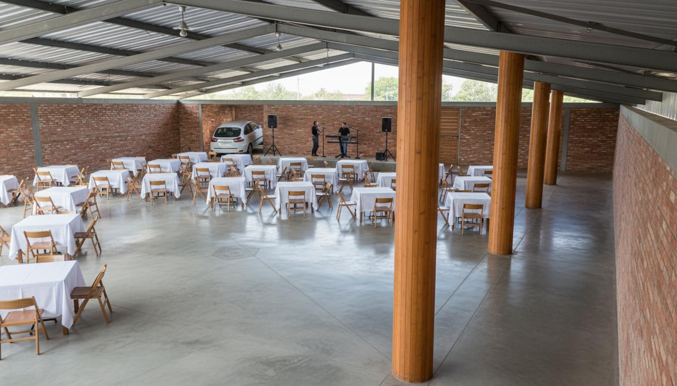 An incredibly lifelike, richly detailed, photorealistic interior photo of a fiesta hall set in a modern fusion environment. The scene is illuminated by diffuse midday light, creating a bright and welcoming atmosphere within the spacious venue. Captured with a wide-angle lens, it emphasizes the polished concrete floor with its subtle stamped concrete line and the exposed brick walls that add a rustic charm. The high ceiling, constructed from corrugated metal with grey ironwork, suggests an industrial-chic aesthetic. A raised stage at the far end features two figures, hinting at a performance or presentation, with a car parked behind, perhaps for a unique display. Numerous tables, draped in crisp white linens and set with chairs, are arranged across the floor, suggesting a banquet or event setting. Large, warm wooden columns punctuate the space, their smooth texture contrasting with the rough brickwork and offering structural support. The overall impression is one of an adaptable, stylish space ready to host a vibrant gathering.