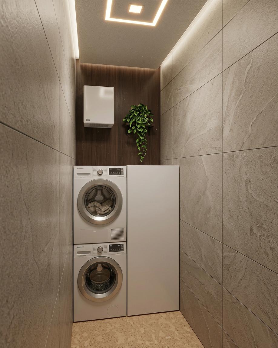 An incredibly lifelike, richly detailed, photorealistic interior photo of a modern fusion hotel bathroom. The scene is illuminated by subtle recessed ceiling lighting and a warm glow from a single overhead square fixture, creating a tranquil and inviting atmosphere. Captured with a wide-angle lens, emphasizing the clean lines and functional layout, this rendering showcases the sophisticated blend of materials. Large format, textured porcelain tiles in a neutral stone hue clad the side walls, providing a sense of depth and sophisticated simplicity. Opposite, a feature wall of rich, dark wood paneling adds warmth and a touch of natural elegance. Stacked front-loading washer and dryer units in white are neatly integrated, flanking a seamless, tall white cabinet, suggesting ample storage. The floor is finished with a light, cork-like material, offering a comfortable and contrasting texture. A small, modern white ventilation unit is mounted on the wood paneling, and a lone, trailing green plant adds a touch of organic life, enhancing the serene and contemporary feel of the space.