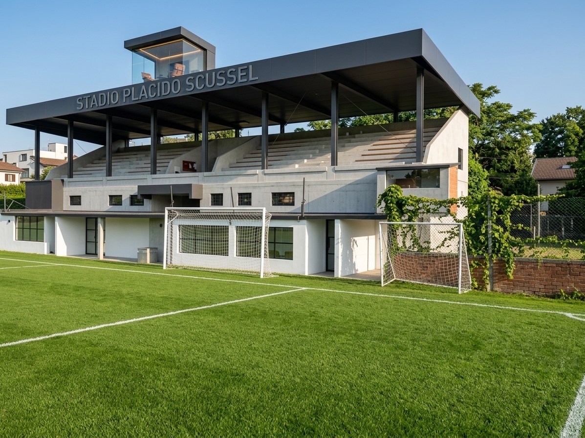 An incredibly lifelike, richly detailed, photorealistic wide-angle architectural photo of a beautifully renovated modern stadium grandstand set in a vibrant, pristine sports facility. The scene is illuminated by bright afternoon sunlight, creating a clean, energetic, and sophisticated atmosphere. Captured with a Hasselblad H6D-100c and a 24mm prime lens, emphasizing the smooth textures of premium fair-faced concrete, matte charcoal metal panels, and warm timber accents.

The design faithfully respects the original structure's silhouette: the grand, cantilevered rectangular roof canopy is now clad in sleek, rust-free matte composite panels with clean, razor-sharp edges, while the slender structural columns are reinforced and finished in refined dark steel. The tiered concrete bleachers are restored to polished light-grey concrete with integrated minimalist timber benches. The rusted upper press box is transformed into an exclusive, minimalist VIP glass pavilion—a cozy media lounge and high-tech gaming room featuring microcement walls, warm ambient LED lighting, and designer furniture visible through floor-to-ceiling glass. On the front fascia, the original name is elegantly reinterpreted in modern recessed steel typography. Below, the old dugouts are retrofitted into minimalist player lounges with white plaster finishes and black steel-framed glazing, looking out onto a perfectly manicured, vibrant green grass pitch under a clear blue sky.