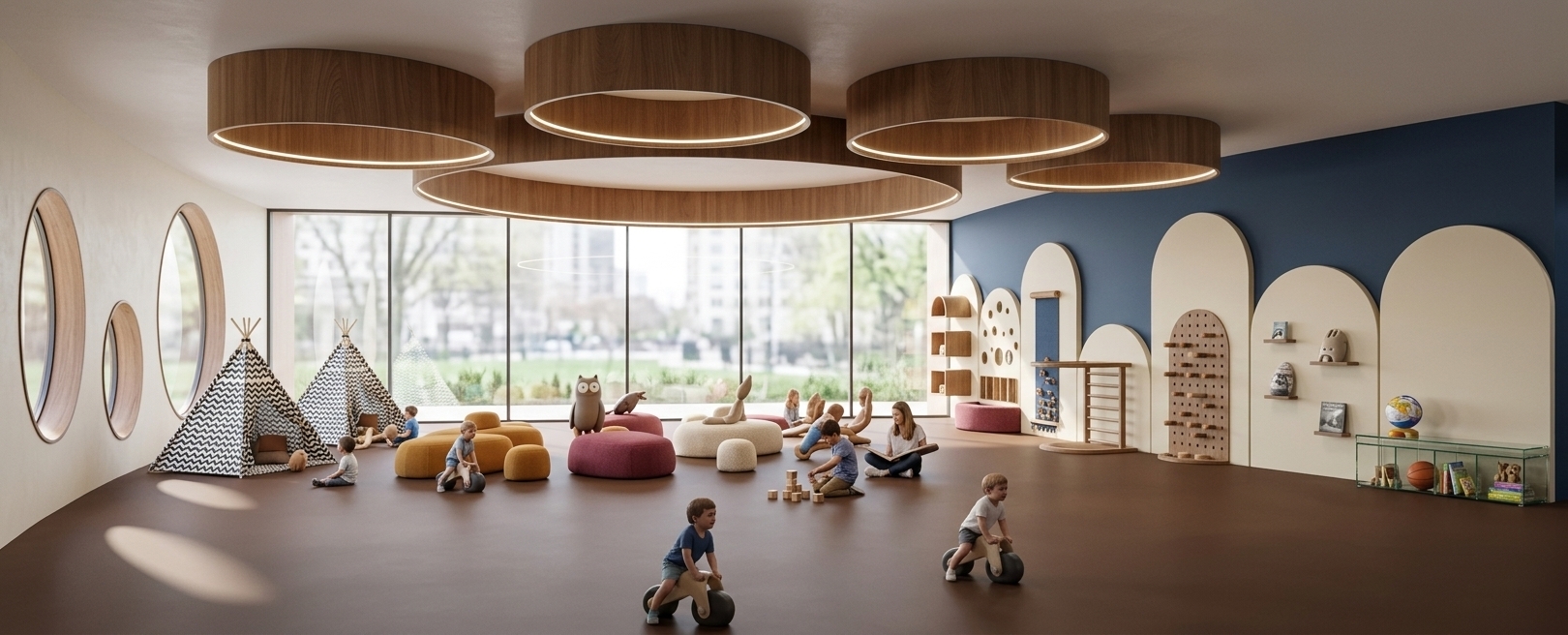 An incredibly lifelike, richly detailed, photorealistic wide-angle interior photo of a dynamic, modern fusion children's play and activity room set in a contemporary urban pavilion. The scene is illuminated by the bright, filtered light of a spring midday streaming through a massive panoramic rear window and unique capsule-shaped side windows, creating a vibrant, inviting, and clean atmosphere. Captured with a professional 24mm architectural lens, emphasizing the seamless matte texture of the chocolate-brown safety flooring, the sleek wood grain of the massive interlocking circular ceiling baffles, and the tactile contrast of patterned black-and-white canvas teepees. The open-concept space features bold, deep blue walls lined with minimalist, modular arched niches painted in soft cream, showcasing wooden climbing structures, dynamic sensory toys, and a curated photography book displayed alongside minimal yet impactful decor. Smooth geometric surfaces, warm ochre and berry-toned modular seat poufs, subtle metallic accents on the modern storage console, and a hint of lush greenery framing the outdoor view complete this sophisticated, industrial-inspired design.