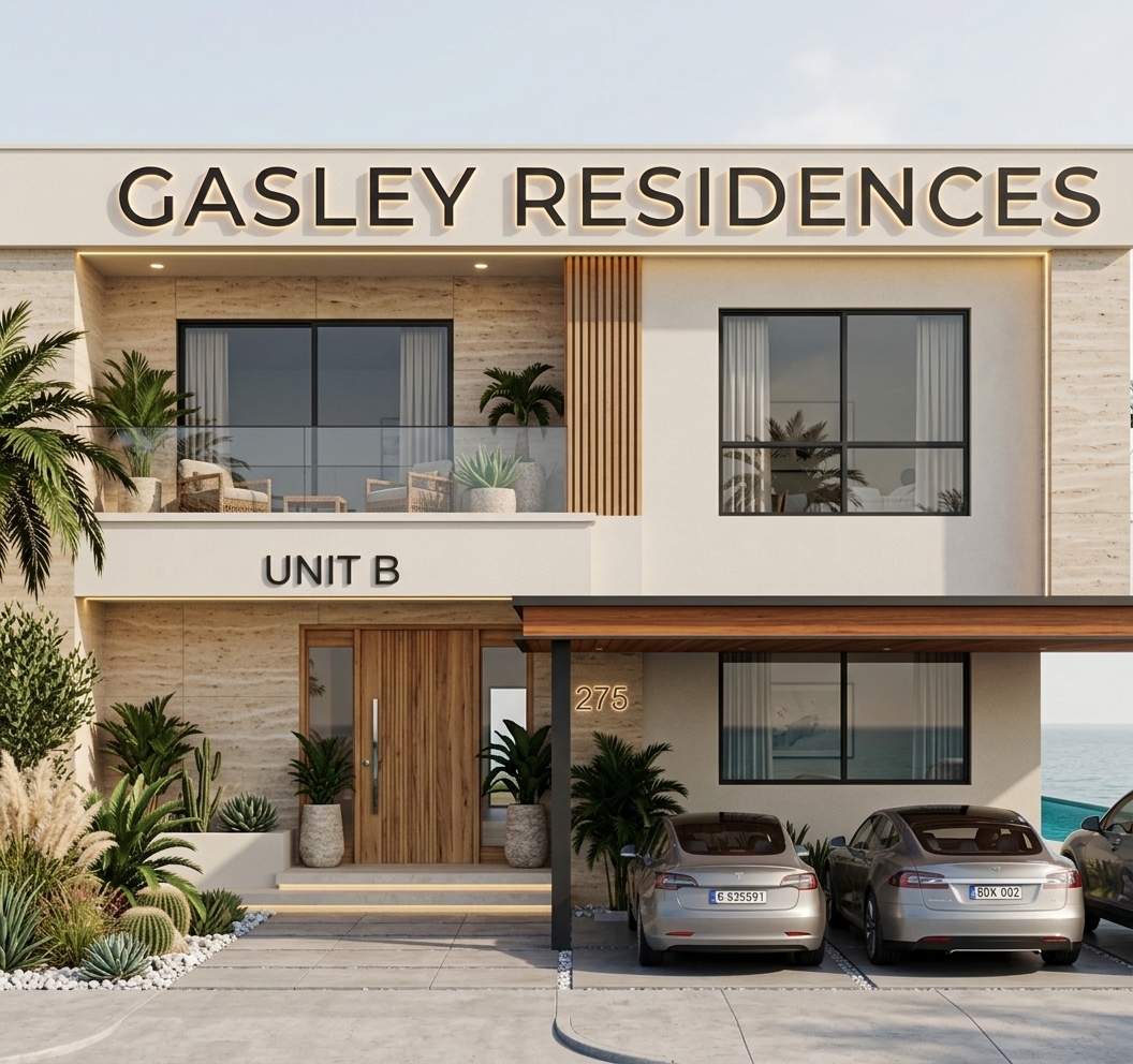 An incredibly lifelike, richly detailed, photorealistic eye-level exterior architectural photo of a contemporary luxury residence titled 'GASLEY RESIDENCES - UNIT B' set in an exclusive seaside coastal spring environment. The scene is illuminated by bright, clear midday spring sunlight paired with soft, warm LED backlighting behind the modern block lettering and under soffit ledges, creating a warm, sophisticated, and tranquil bohemian oasis atmosphere. Captured with a professional 35mm architectural tilt-shift lens, emphasizing the fine textures of beige vein-cut travertine stone tiles, warm natural timber, smooth off-white stucco exterior finishes, and polished concrete driveway slabs. The two-story facade features an expansive upper balcony with glass railings revealing outdoor wicker seating framed by lush potted palms and succulents, while the ground floor boasts a grand vertical-slat timber front door with glass sidelights. Beneath a sleek, dark carport with rich wood soffit paneling sit two luxury electric sedans, parked on a drive surrounded by meticulously curated desert-bohemian landscaping complete with pampas grass, cacti, low-lying tropical greenery, and white river pebbles. To the far right, a sliver of a deep turquoise infinity pool seamlessly bleeds into the calm ocean horizon under a soft, hazy sky, bringing together an effortless blend of globally-inspired warmth, modern elegance, and coastal luxury.