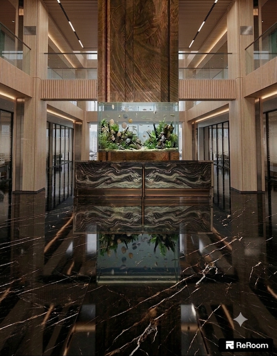 This photograph of a grand luxury atrium captures realistic, tangible architectural surface textures illuminated by a refined blend of warm recessed ambient lighting and cool ambient daylight. The light-toned wooden columns and upper mezzanine walls showcase authentic wood grain details with fine tactile micro-grooves, matte satin finishes, and subtle natural panel seams. The central carved bronze-brown feature column displays deep relief textures and a rich metallic sheen, housing a brightly illuminated glass aquarium filled with vivid aquatic plants, clear water caustics, and subtle glass refractions. In the foreground, the dark swirl-patterned reception desk features polished exotic marble textures with delicate metallic brass trim along its edges. The floor is composed of high-gloss black marble with crisp white veining, casting perfectly aligned, physically accurate specular reflections of the lobby structure, desk, and aquarium above. Shot on a full-frame architectural camera with a wide-angle lens, the image displays realistic depth of field, crisp material clarity, balanced color temperature, and subtle photographic nuances like micro-surface imperfections and soft light falloff along the perimeter.
