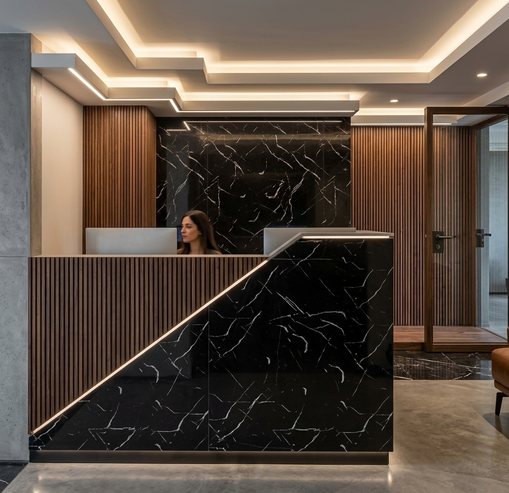 An incredibly lifelike, richly detailed, photorealistic eye-level interior photo of a sleek modern fusion reception desk and entry space set in a luxury contemporary foyer. The scene is illuminated by concealed ceiling cove lighting and warm, luminous integrated LED strip accents glowing along crisp diagonal seams and plinths, creating an intimate, dramatic, and sophisticated atmosphere. Captured with a 35mm architectural lens, emphasizing the rich juxtaposition of polished black Marquina marble with striking white veining, finely ribbed vertical wood slats, and smooth exposed architectural concrete wall finishes (*concreto aparente*). The geometric, split-material reception counter seamlessly anchors the composition, backed by a matching high-gloss stone feature wall and warm slatted screens that exude refined craftsmanship and modern elegance.