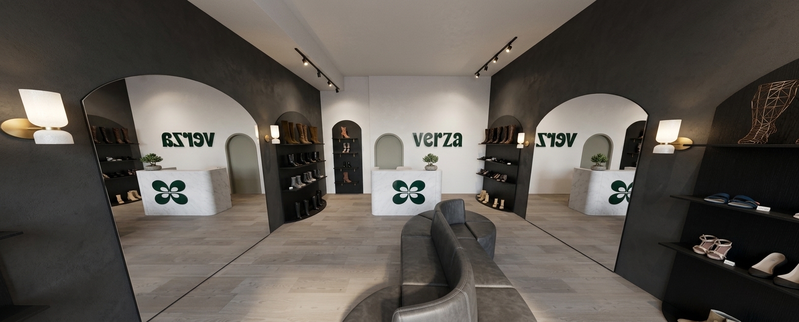 A realistic interior photograph of a modern shoe boutique, preserving the exact geometry and wide-angle perspective. The floor is made of large, matte beige-gray ceramic tiles with subtle texture. Side walls are finished in a smooth, muted greenish-gray plaster, while the focal front wall is painted a soft light gray featuring the dark green "verza" logo and motif. Elegant black painted arches frame black melamine shelving displaying leather shoes and boots, accompanied by clean arched mirrors reflecting the interior. A curved, double-sided dark gray upholstered seating island sits centrally, complemented by a light gray microcement reception counter in the background. Illumination comes solely from warm ceiling track spotlights focused precisely onto the retail shelves, accented by glowing minimalist wall sconces, casting soft ambient falloff and realistic specular reflections throughout the space.