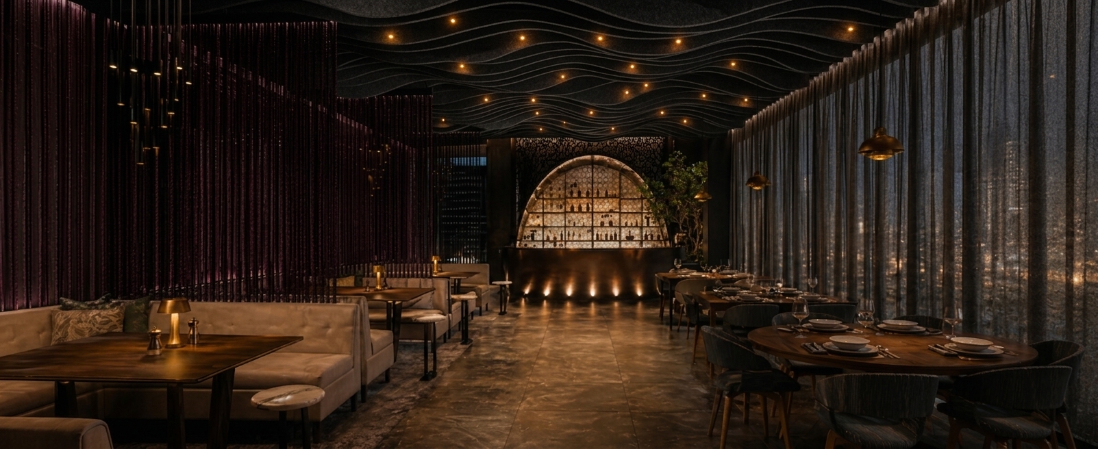 A professional architectural interior photograph capturing the moody, upscale restaurant scene with its exact layout, dining tables, plush booth seating, sheer floor-to-ceiling drapery, and illuminated arched bar at the far end. The dark ceiling is rendered with undulating black acoustic felt baffles with soft, wave-like edges that integrate subtle warm pinpoint downlighting. Captured on a 35mm wide-angle lens at eye level, the lighting emphasizes the rich, warm amber glows from table lamps, soft reflections on polished dark stone flooring, and sheer fabric textures. Natural photographic fidelity is achieved with balanced dynamic range, realistic shadows, gentle atmospheric depth, subtle optical vignetting, and fine sensor grain.