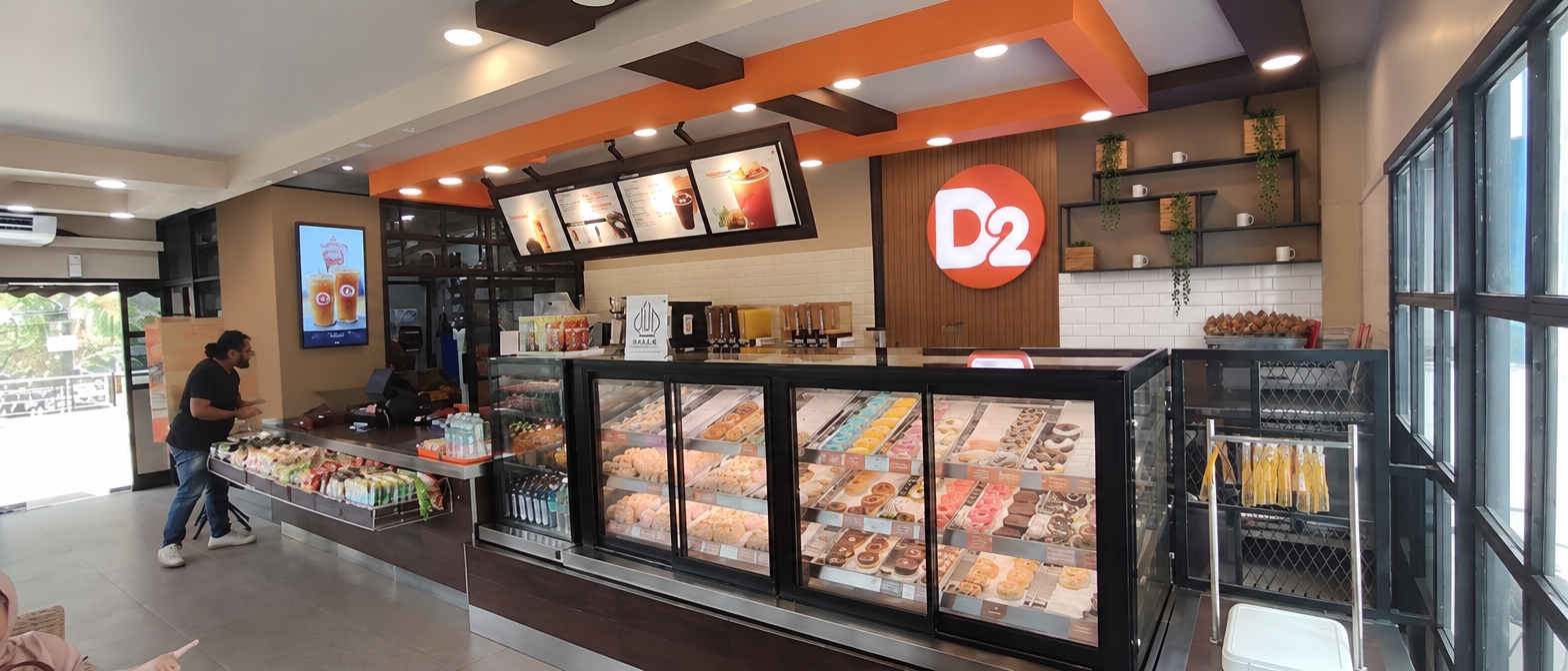Foto pertama yang ada logo gelas dan tulisan coffe n more diganti seperti di foto kedua ada logo D2 bulat dan rak besi.
di foto pertama gambar poster tulisan Dunkin Quality diganti formika warna cappucino polos dan dipasang TV 50 '' dipasang vertikal
difoto pertama ada poster yang gambar donat donat diganti dengan formika warna cappucino polos seperti difoto ketiga
dinding yang ada logo bulat D2 dibuat sama persis seperti di foto kedua yang sebelumnya, rak besinya hanya disebelah kanan dari costumer. dibelakang logo bulat D2 dipasang grill vertikal kayu seperti di foto kedua
dinding besi yang diarea TV menu dipasang vertikal dikembalikan lagi seperti di gambar sebelumnya.
dinding dibelakang panel menu kembali ke gambar foto pertama, grill kayu vertikal hanya sampai dengan kolom besi coklat di foto pertama (kolom besi coklat tertutup kayu vertikal). yang memakai dinding vertikal kayu hanya dibelakang logo bulat D2. seperti difoto kedua, dibawah rak besi memakai keramik 10x20 cm dipasang susun bata, bagian belakang rak besi dicat warna cappucino.