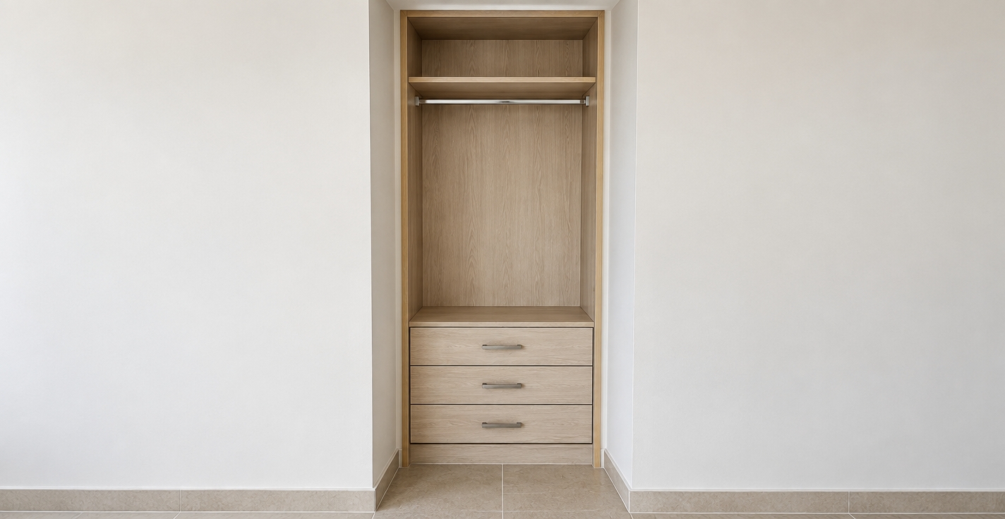 A straight-on interior architectural photograph of the built-in closet, maintaining the exact perspective, composition, and structural layout without the CAD diagram overlays. The cabinetry features realistic light wood laminate and melamine with delicate micro-grain textures, fitted with brushed metal handles and a matching chrome hanging rod. Soft, diffused ambient interior lighting casts gentle, natural contact shadows inside the cubby, beneath the top shelf, and along the three lower drawers. The surrounding recessed drywall frame displays a smooth matte painted finish, resting atop genuine ceramic floor tiles with fine grout lines. Shot with an eye-level lens, balanced neutral color temperature, sharp depth of field, and subtle sensor grain for complete photorealism.