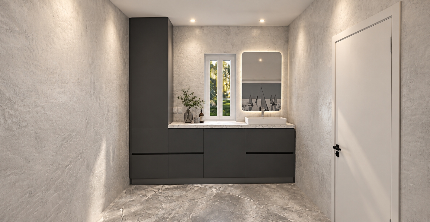 The photo reveals a minimalist haven within a modern bathroom, characterized by clean lines and a serene color palette. The architectural style leans towards contemporary minimalism, with an emphasis on functional elegance. The walls are finished in a light, almost white plaster or stucco, exhibiting a subtle, textured roughness that adds depth without detracting from the room's uncluttered aesthetic. Complementing this, the floor is adorned with large format, light gray marble-effect tiles, featuring delicate darker veining that creates a luxurious yet understated foundation. Dominating the back wall is a sleek, dark gray modular cabinet system: a tall, slender vertical unit stands to the left, seamlessly integrating with a wider lower vanity unit. This vanity boasts handleless drawers and doors, contributing to its streamlined appearance, and is topped with a pristine white or very light gray speckled quartz countertop, upon which rests a crisp white rectangular vessel sink. Above the sink, a large, rounded-corner rectangular mirror reflects a tranquil scene of sailboats on water, adding an unexpected artistic touch and visually expanding the space. To the left of the mirror, a narrow, vertically oriented window with a simple white frame offers a glimpse of soft, blurred greenery and warm yellow foliage outside, suggesting a peaceful natural setting, possibly during autumn, and providing natural illumination to the space. On the right, a simple, light gray paneled door with a contrasting black handle integrates subtly into the wall, maintaining the room's cohesive design. The ceiling is a plain, flat gray, implying indirect or recessed lighting that further enhances the bright, airy atmosphere of this functional and tranquil sanctuary.