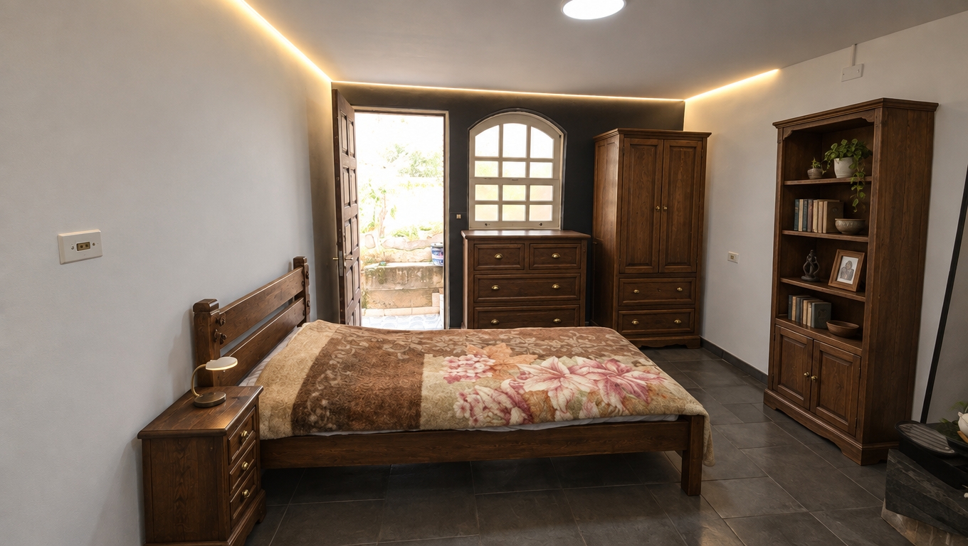An incredibly lifelike, richly detailed, photorealistic wide-angle interior photograph of a modern fusion bedroom set in a peaceful home. The scene is illuminated by glowing perimeter LED cove lighting paired with bright natural daylight pouring through the doorway and arched window, creating a warm, inviting, and tranquil atmosphere. Captured with a 24mm wide-angle lens, emphasizing the rich organic grain of antique solid brown wood, subtle aged patinas, and the tactile contrast between classic carpentry and clean modern walls.

Preserving the original architecture, walls, tiled flooring, and structural openings exactly as they are, the cyan sketches are seamlessly realized into handsome, heirloom-quality solid wood furniture in a deep antique brown finish. Beside the existing bed stands a matching slender wooden nightstand with smooth carved edges and vintage brass pulls. Centered beneath the arched window, a solid hardwood chest of drawers offers robust functional storage, perfectly proportioned to sit just below the sill. Next to it stands a tall, elegant wooden wardrobe armoire complete with double paneled doors above and stacked lower drawers. Along the right wall, a matching tall open-shelf bookcase with a lower two-door cabinet completes the suite, bringing sophisticated balance and handcrafted warmth that harmonizes effortlessly with the room's contemporary perimeter lighting.
