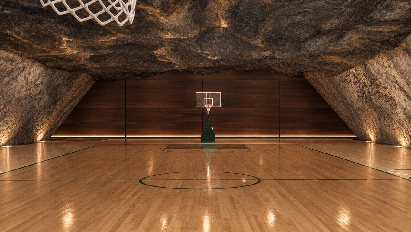 An incredibly lifelike, richly detailed, photorealistic interior shot of a bespoke subterranean sports court set in a rugged mountain escape. The scene is illuminated by soft, diffused ambient light that filters through the cavernous space, creating a serene and meditative atmosphere. Captured with a 35mm wide-angle lens, the composition emphasizes the stark contrast between the sleek, polished hardwood floor and the raw, natural stone walls that flank the court. Above, a dramatic, vaulted ceiling features dark, weathered rock formations with subtle marbling, echoing the ancient geology of the surrounding alpine environment. The back wall, composed of dark timber paneling, provides a grounding element that draws the eye toward the central basketball hoop, which stands as a functional sculpture within the cavern. The interplay of textures—from the smooth, golden grain of the maple flooring to the gritty, porous surface of the cave-like walls—is rendered with exquisite clarity. Subtle design accents, such as deep emerald green and warm chocolate brown tones, subtly integrated into the court markings and shadows, evoke a cozy, cabin-inspired aesthetic, making this hidden gymnasium feel like an intimate, exclusive retreat nestled deep within a mountainside.
