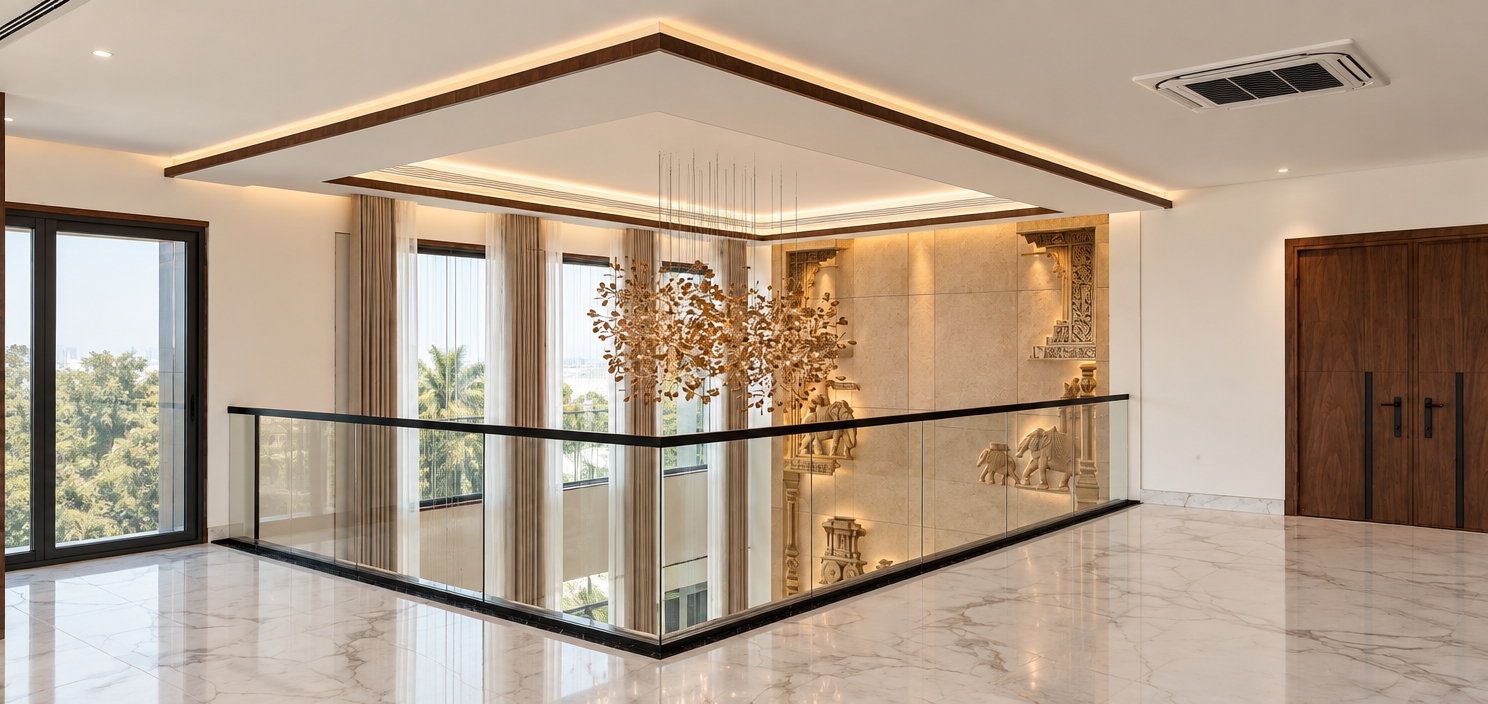 A crisp architectural photograph captures this exact double-height interior mezzanine, illuminated by balanced ambient daylight and warm accent sources. The floor is rendered in polished white Statuario marble with sparse, delicate grey veining, contrasting cleanly with the clear glass railing and its sleek black metal handrail. Across the void, the double-height feature wall showcases deeply carved sandstone reliefs of traditional Indian elephant motifs, brought to life with tactile micro-textures and rich dimensional shadows cast by warm raking light. Suspended in the center, the organic twig chandelier emits a soft, warm glow. Pristine white walls and a flush white tray ceiling enclose the space, framed on the right by a matte walnut veneer double door and in the background by four wood-trimmed windows dressed in sheer white tissue and beige drapery, all captured with natural optical clarity and subtle atmospheric depth.